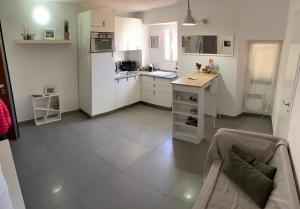 a kitchen with white cabinets and a couch in a room at Magici ricordi-Bordighera in Bordighera