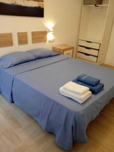 a large bed with blue sheets and towels on it at Precioso apartamento recién reformado in Madrid