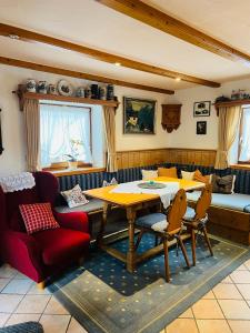 uma sala de estar com uma mesa de madeira e cadeiras em Hexen Haus em Oberau