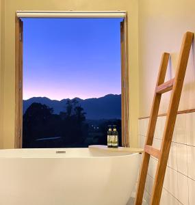 a bathroom with a tub and a window with a view at Monko Villa in Pai