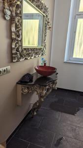 La salle de bains est pourvue d'un lavabo rouge et d'un miroir. dans l'établissement Monteurszimmer in Hof, à Hof