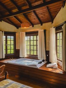 a large bath tub in a room with windows at Pousada Villa da Uva in Gramado