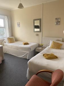 a hotel room with two beds and a chair at Salfordian in Southport