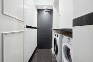a kitchen with a washing machine and a door at Golden Square in London