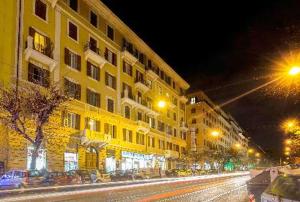 a yellow building on a city street at night at Casa Mirabilia in Rome