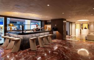 a bar in a hotel with a person standing behind it at Astor Hotel Athens in Athens
