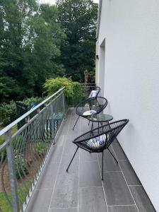 2 sillas y una mesa en el balcón en La maison de l'étang en Ploërdut