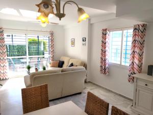 a living room with a couch and a table at NPG429 - Holiday Beach House on the Golf Course in Huelva