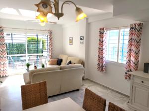 un soggiorno con divano e tavolo di NPG429 - Holiday Beach House on the Golf Course a Huelva