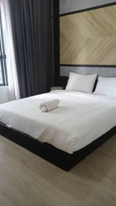 uma cama com uma toalha num quarto em KL City Family Suite 3R2B Arte+ Level 10 em Kuala Lumpur