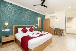 um quarto com uma cama grande e almofadas vermelhas em ESAA Airport Hotel Kochi em Cochin