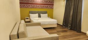 a hotel room with a bed and a couch at SHAMUKA HOTEL in Puri