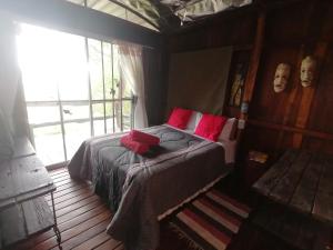 ein Schlafzimmer mit einem Bett mit roten Kissen in der Unterkunft Mukuku Rest Camp in Shimweghe