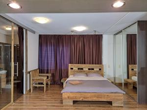 a bedroom with a large bed and a purple curtain at Champêtre Park View Apartments in Rīga