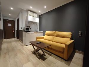 ein Wohnzimmer mit einem gelben Sofa und einem Tisch in der Unterkunft Pensión Astigarraga in Astigarraga