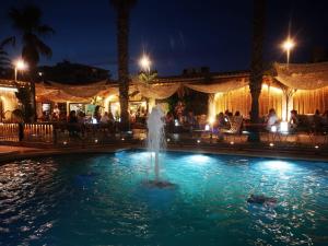 - une fontaine au milieu d'une piscine la nuit dans l'établissement LEON INMO Apartment Oasis - 10022, à Empuriabrava