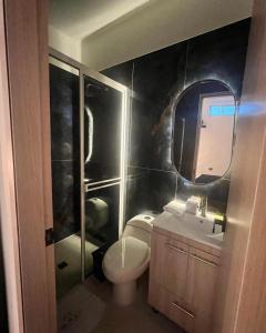 ein Badezimmer mit einem WC, einem Waschbecken und einem Spiegel in der Unterkunft HOTEL MASS LUXURY in Doradal