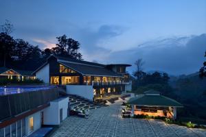 a villa with a view of the mountains at night at Coorg Marriott Resort & Spa in Madikeri