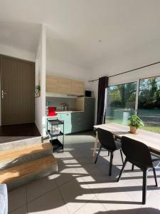 uma sala de estar com mesa e cadeiras e uma cozinha em Le Clos des Eaux em Tailly