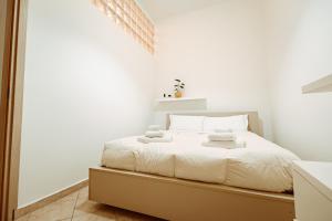 a white bedroom with a bed with towels on it at Loft Pozzo Strada in Turin