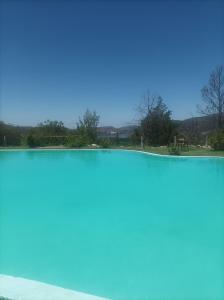 un bassin d'eau avec un ciel bleu en arrière-plan dans l'établissement Posada el antiguo refugio, à Potrero de los Funes