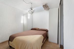 a bedroom with a bed in a white room at Apartamento El Moral in Frontera