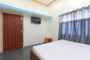 1 dormitorio con 1 cama y puerta de madera en Hotel Atithi Satkar , Gobarsahi, en Muzaffarpur