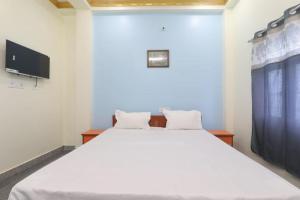 a bedroom with a white bed and a tv at Hotel Atithi Satkar , Gobarsahi in Muzaffarpur