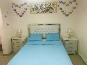 1 dormitorio con 1 cama azul y 2 mesitas de noche en Réservez votre Studio avec Spa, Parking privé & Cuisine à Ciudad del Sol en Punta Cana
