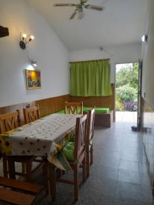 comedor con mesa y cortina verde en Sierras Del Sol en Villa Carlos Paz