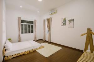 Habitación blanca con cama y ventana en Nha Trang Riverside Villa en Nha Trang