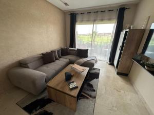 uma sala de estar com um sofá e uma mesa de centro em Prestigia appartement de lux em Marrakech