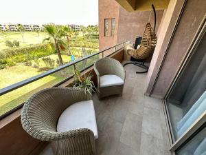 a balcony with wicker chairs and a computer on it at Prestigia appartement de lux in Marrakesh