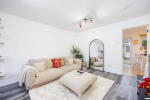 a living room with a couch and a mirror at OFFERS - Modern East London Home Contractors Parking Sleeps 5 Near ExCeL London in London