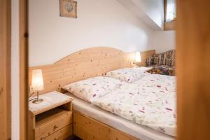 1 cama con cabecero de madera en un dormitorio en Appartement Anton, en Sand in Taufers