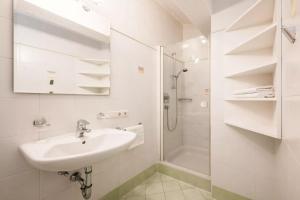 a white bathroom with a sink and a shower at Appartement Anton in Sand in Taufers