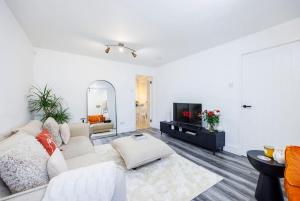 un soggiorno con divano e TV di Stylish 2-Bed East London Home Contractors Parking Sleeps 5 Near ExCeL London a Londra