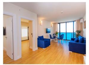 巴統的住宿－P A N O R A M A ORBi city APARTHOEl SEA VIEW，客厅配有蓝色的沙发和桌椅