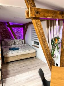 Dormitorio con cama con iluminación púrpura en Brick and Wood Apartment en Bydgoszcz
