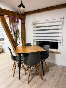 comedor con mesa de madera y sillas en Brick and Wood Apartment en Bydgoszcz
