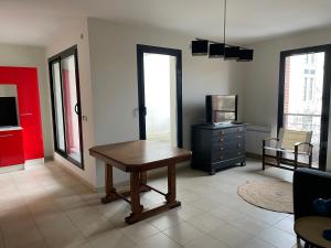 sala de estar con mesa de madera y TV en Pasteur, en Troyes