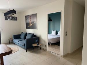 sala de estar con sofá azul y cama en Pasteur, en Troyes