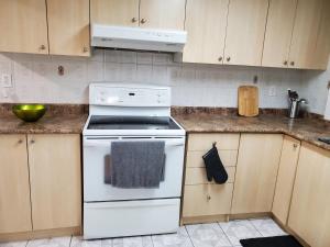 a white stove top oven in a kitchen at Deluxe King Size Ensuite bed room near the airport in Mississauga