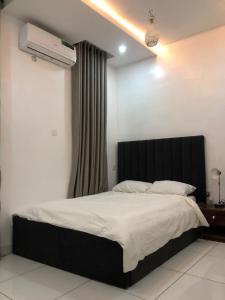 1 dormitorio con 1 cama con cabecero negro en Luxury apartments en Ibadán