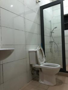 een badkamer met een toilet, een douche en een wastafel bij Luxury apartments in Ibadan