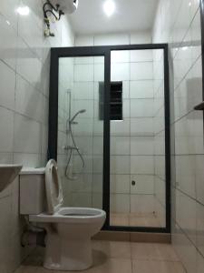 a bathroom with a toilet and a shower with a glass door at Luxury apartments in Ibadan