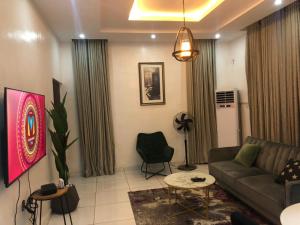 een woonkamer met een bank en een stoel bij Luxury apartments in Ibadan