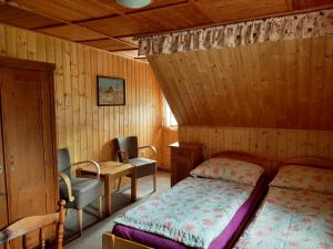 a bedroom with a bed and a desk and a chair at Bouda Na Cestě in Pec pod Sněžkou