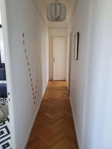 a hallway with white walls and a wooden floor at Suite Forum Vue Imprenable in Reims