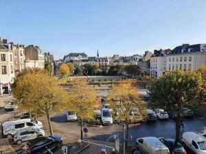 a city with cars parked in a parking lot at Suite Forum Vue Imprenable in Reims